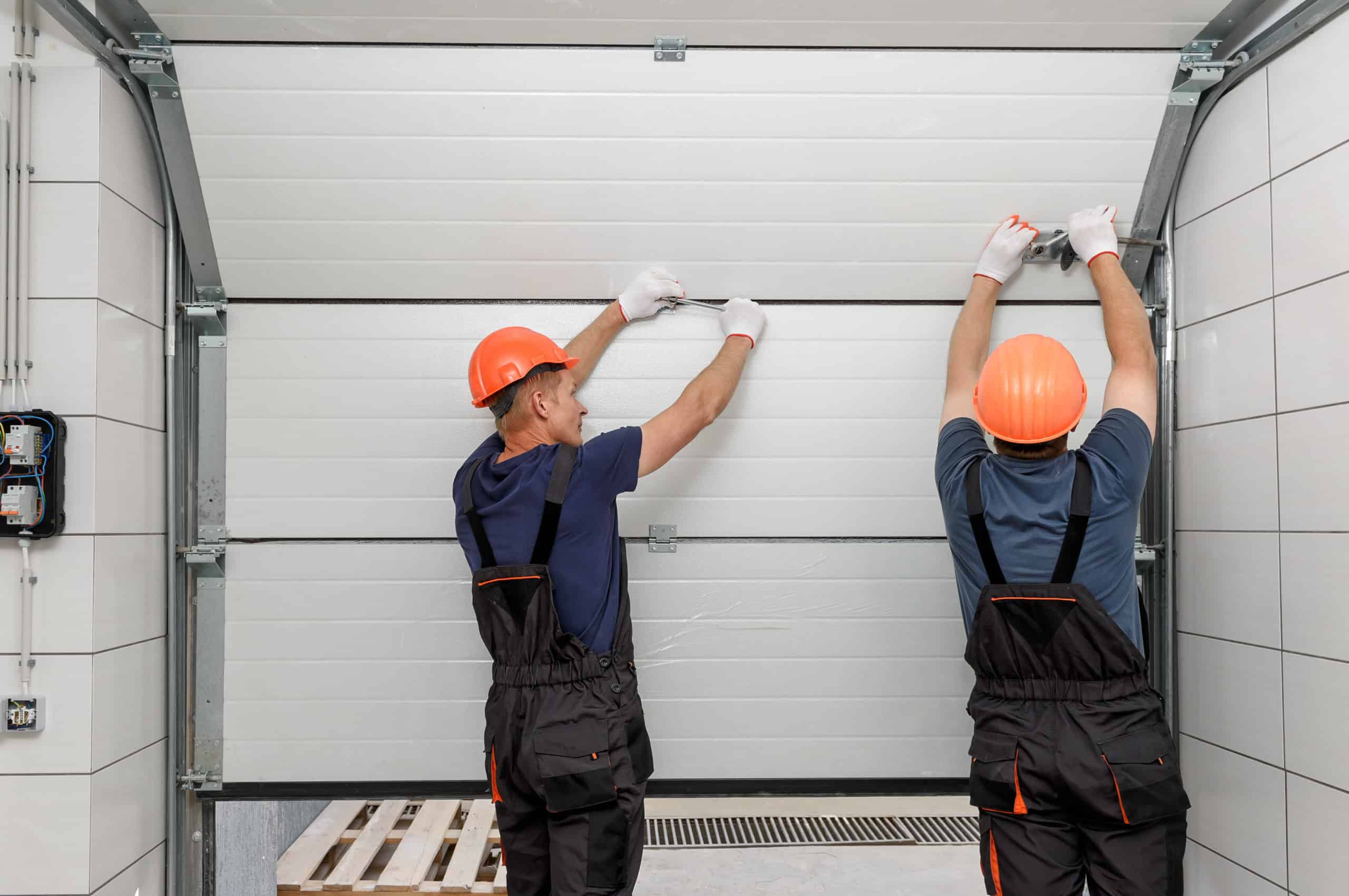 Photograph of garage door repair professionals at work