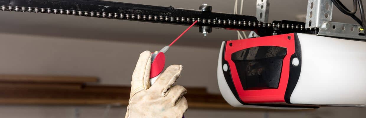 A person lubricating a garage door